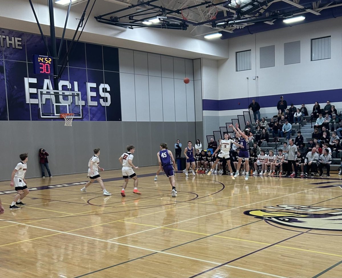 Senior forward, Colton Benson shoots a three-pointer over a Marshall defender.