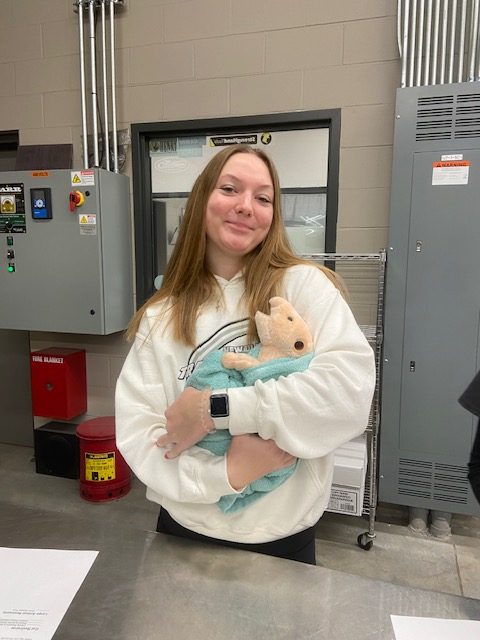 Senior Ella Ahrens holding an earless pig In a "cat burrito" position. (Fan favorite)