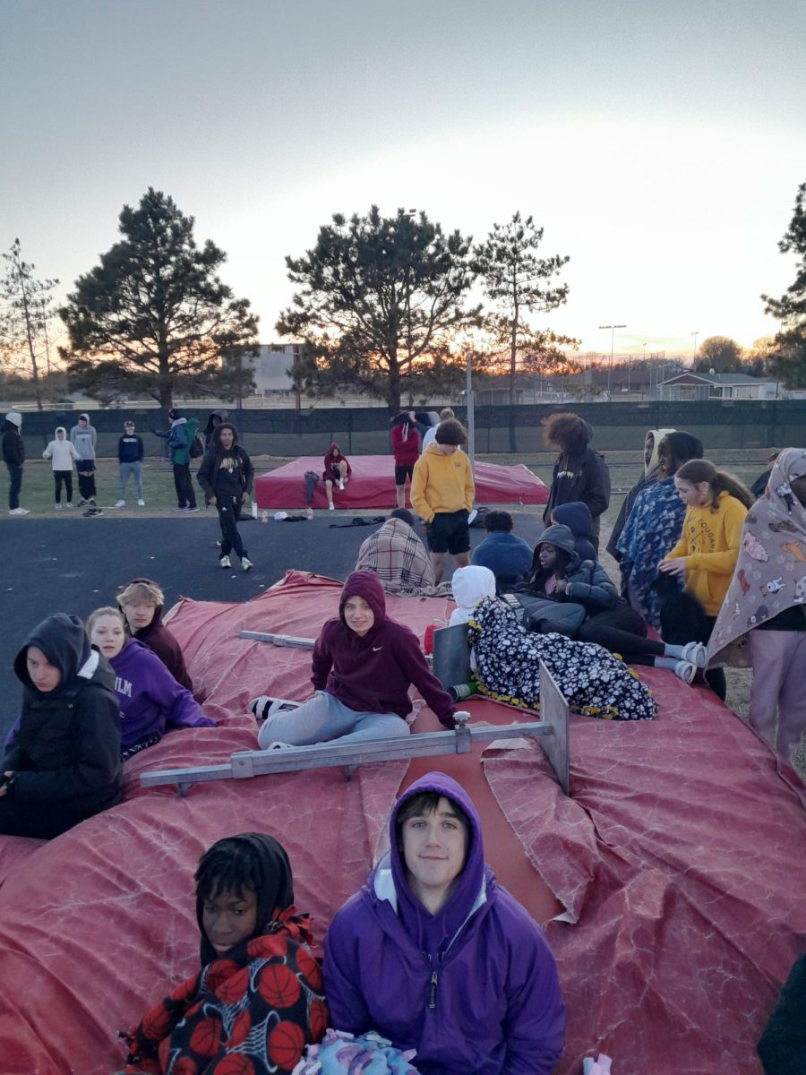 Tracksters rest on the high jump mat after competing 