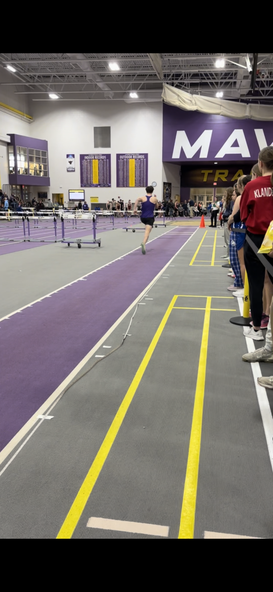 Senior Easton Clark approaching the long jump pit.