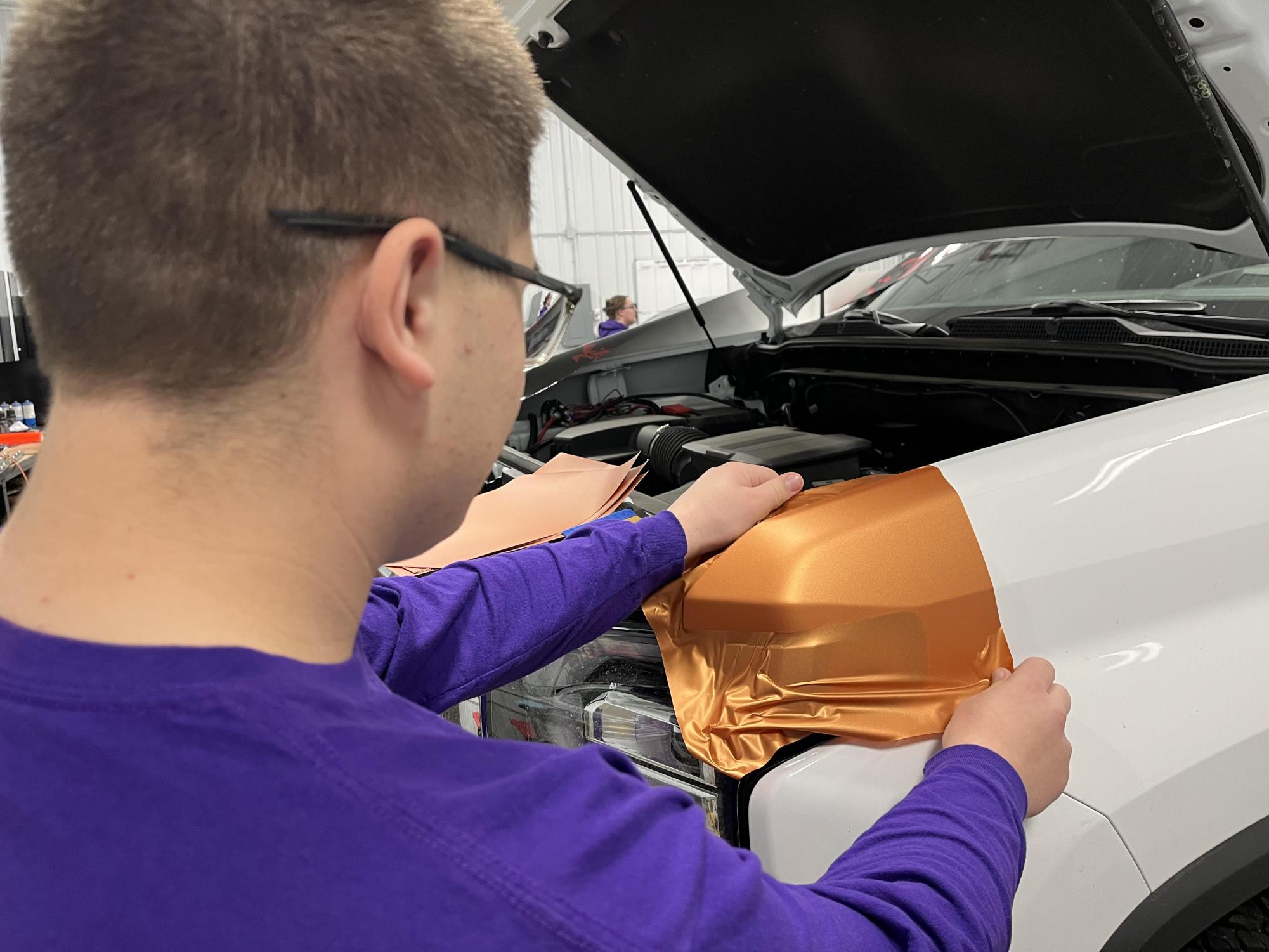 Joey Kotten wrapping a truck at Fuel Graphics.