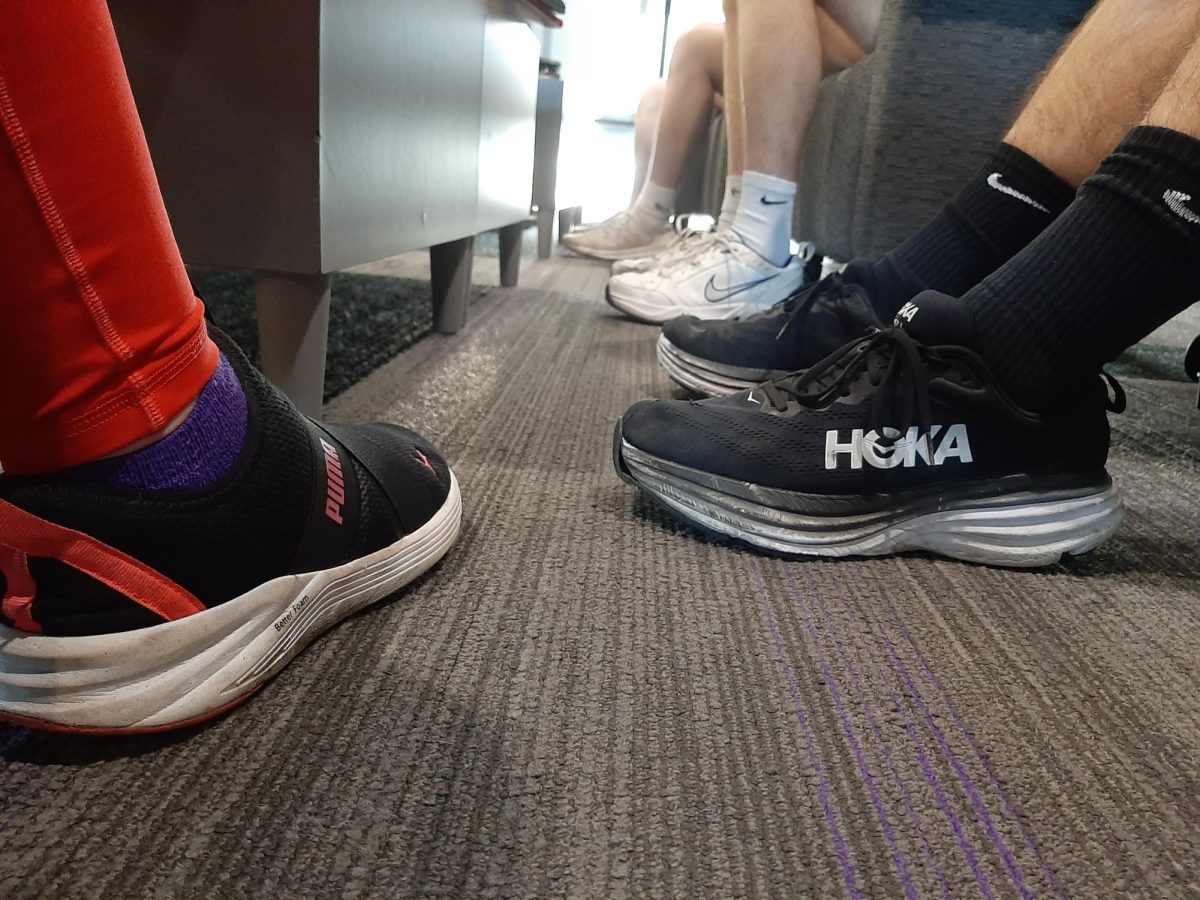 Students converse in the upper commons while flexing their wide variety of shoes.