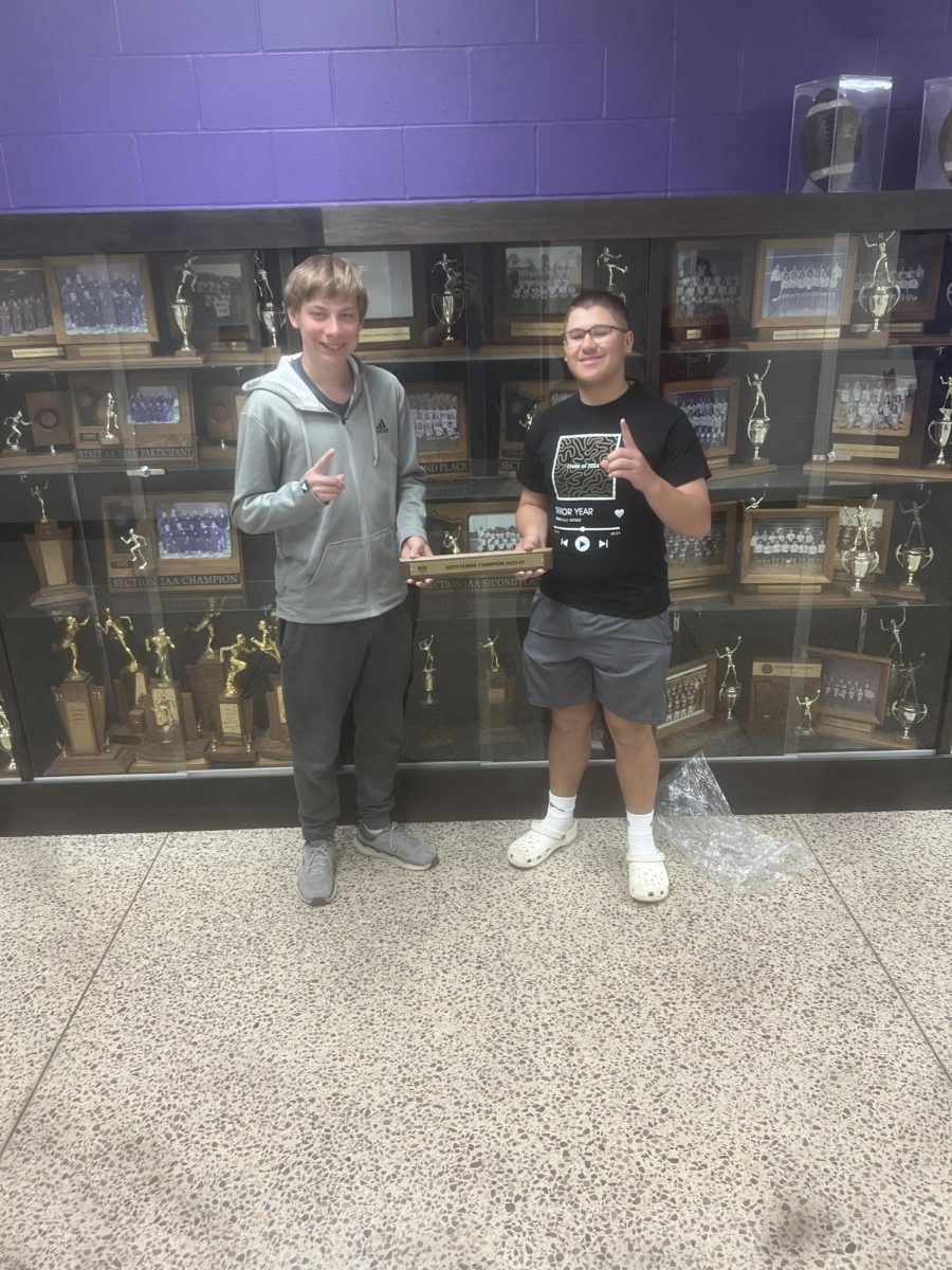 Senior Joey Kotten and Senior Ethan Neet holding up 1s to show who the champs are