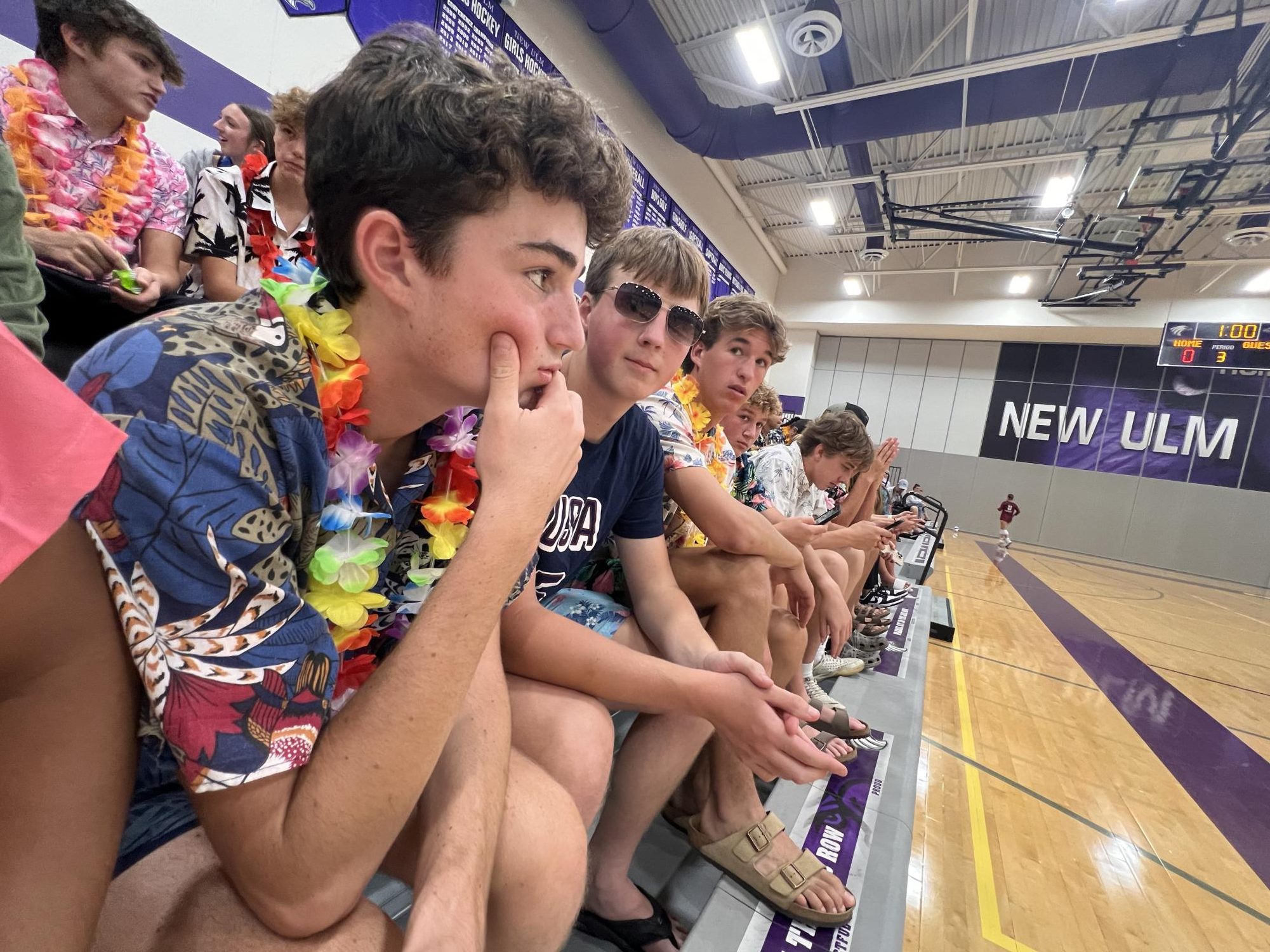 Hawaiian-themed student section watches volleyball secure their first win during homecoming week. 