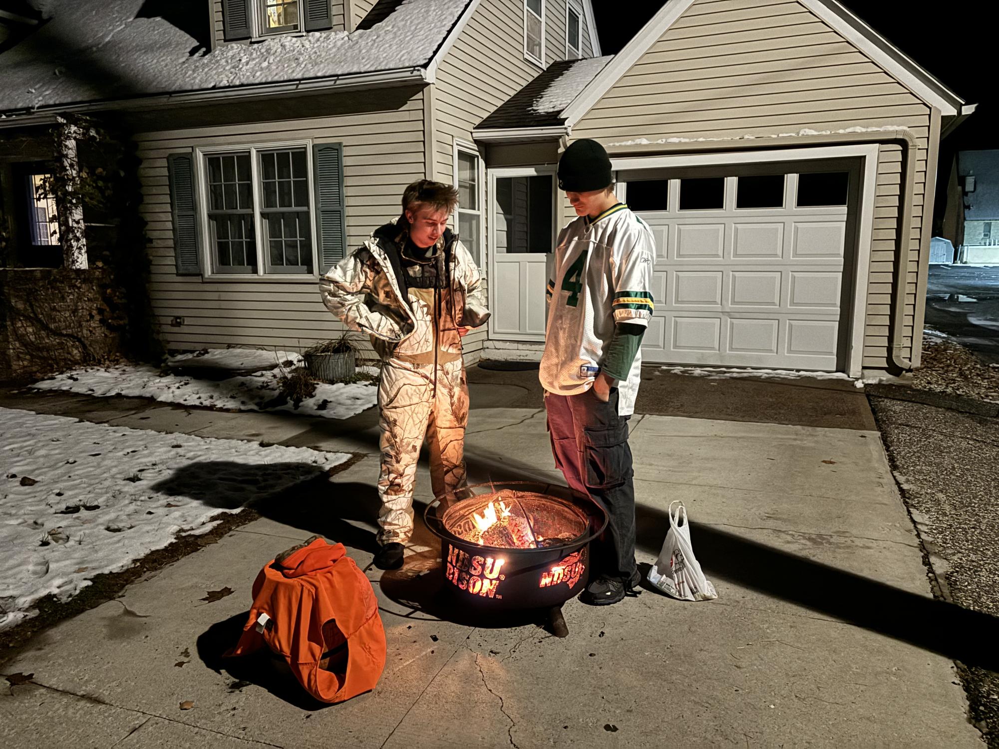 Students Gabe Nosbush and Antony Leonard warming up after a long night of trick or treating