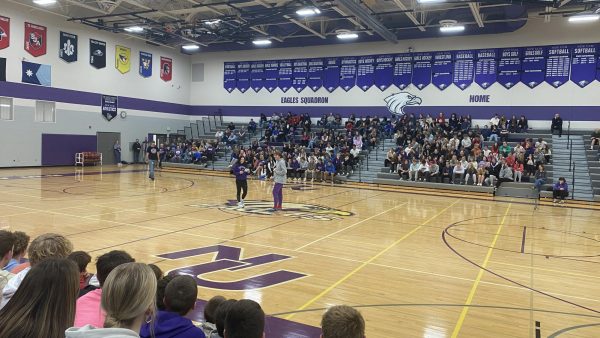 Student council members Natalie Fischer and Owen Castleman announcing the purple and white winners at the pepfest.