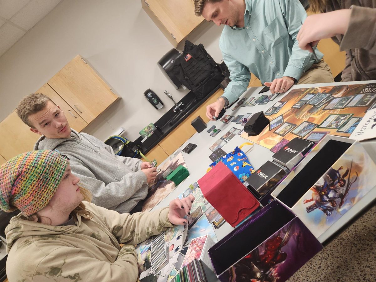 Seniors Simon Fisher and Levi Jensen playing Magic the Gathering with Science Nelson.