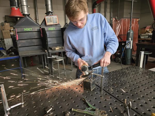 NUHS student Cody Serbus operating an angle grinder safely in the High School shop. 