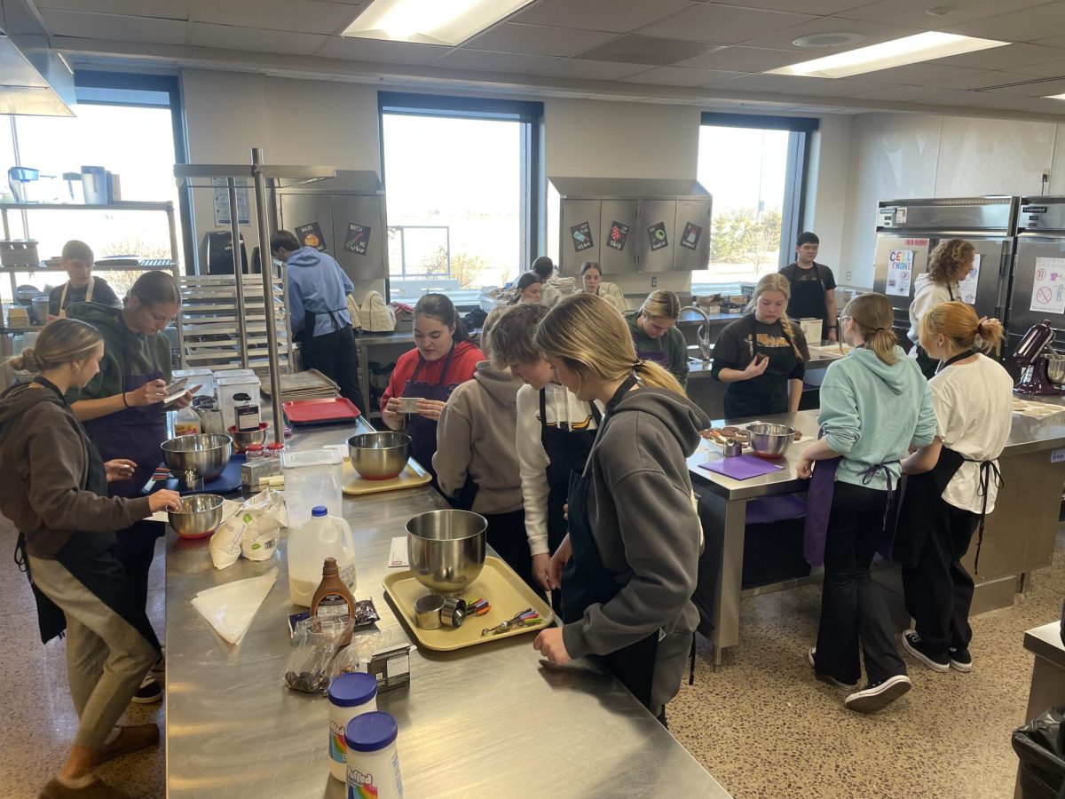 A busy scene in the lab as students prepare ingredients to make copycat Crumbl cookies for basic foods class.