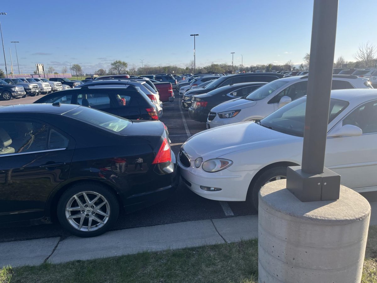White car parked over the lines and touching another car