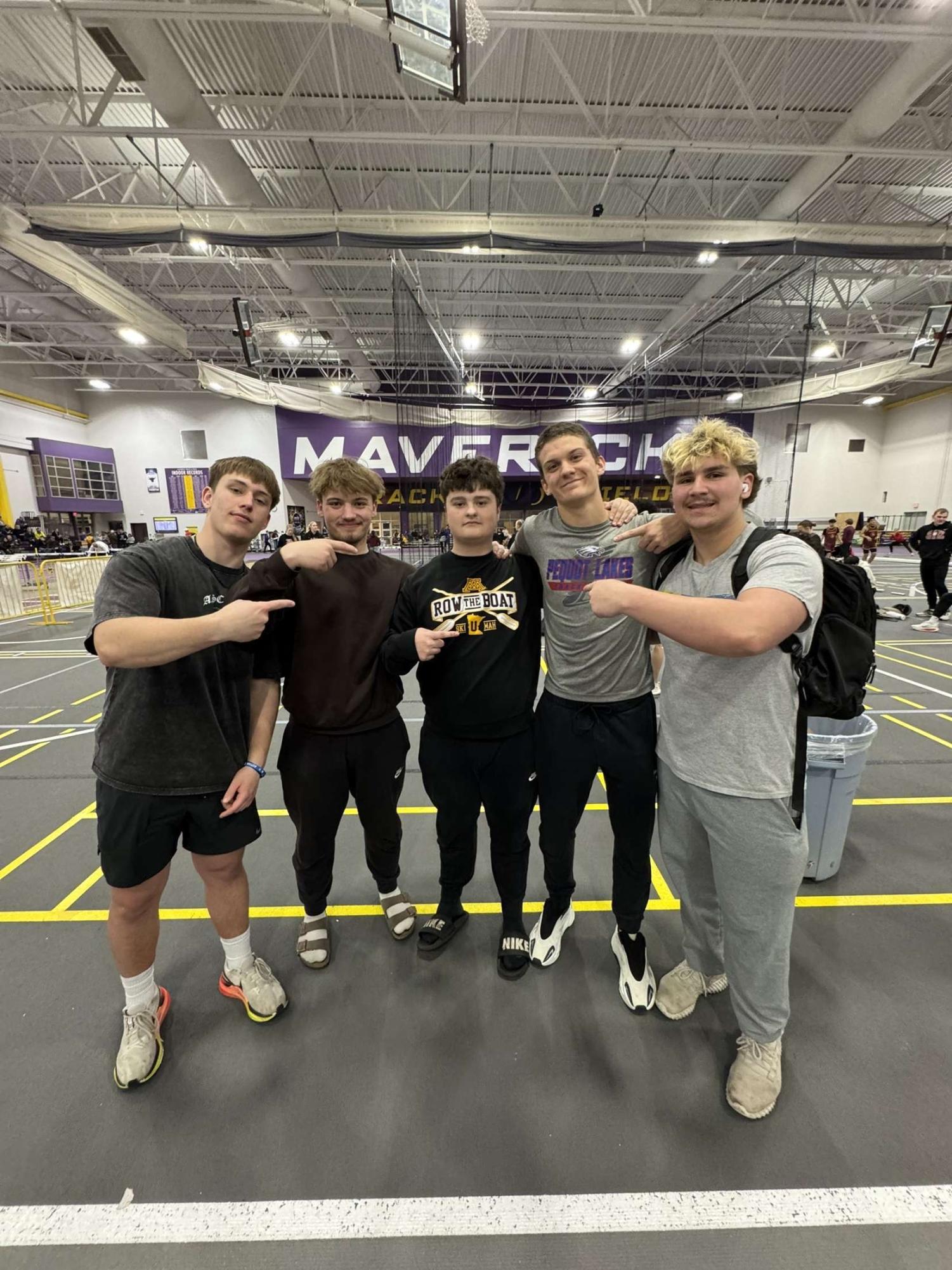 Track athletes (L to R) Senior Sam Ibberson, Senior Brody Hacker, and Sophmore Kaden Schaefer pose with track participants from another school.