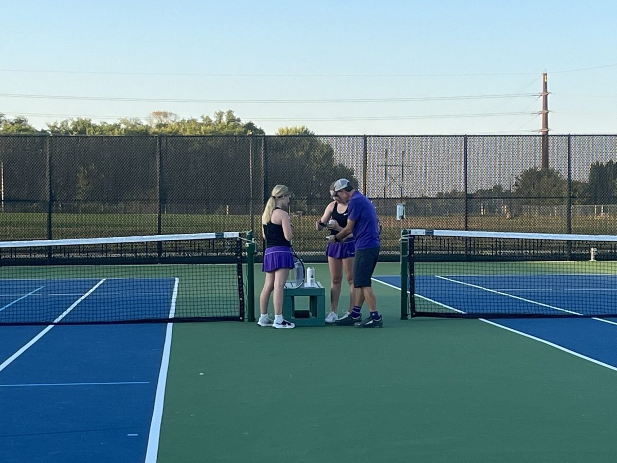 New Ulm tennis coach Mr. E talking to players middle of their game.