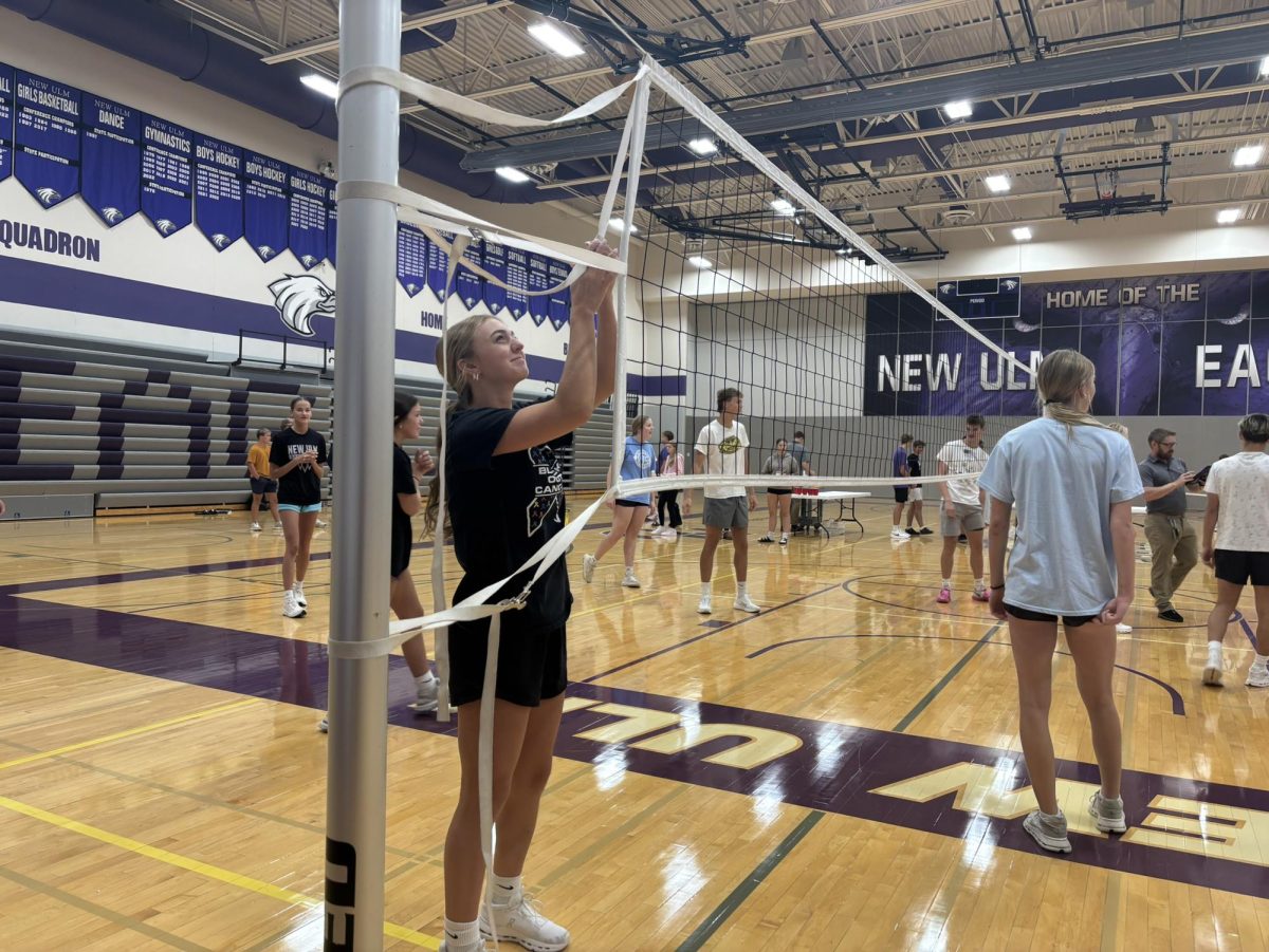 Senior Isabelle Longtin sets up net for the pre round games of volleyball for BOTC.