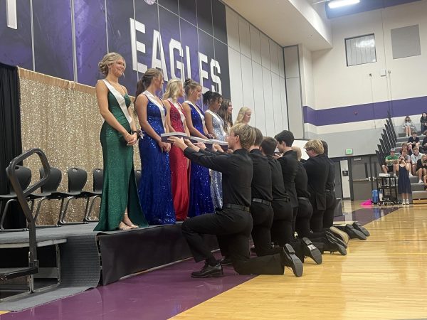 The homecoming queen escorts hold the boxes for the reveal of the new homecoming queen