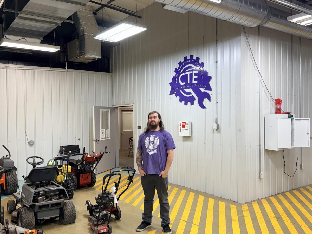 Mr. Dustin posing In front of his classroom