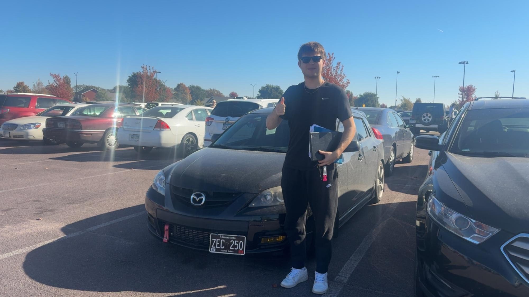 Senior Brody Theis next to his new car 