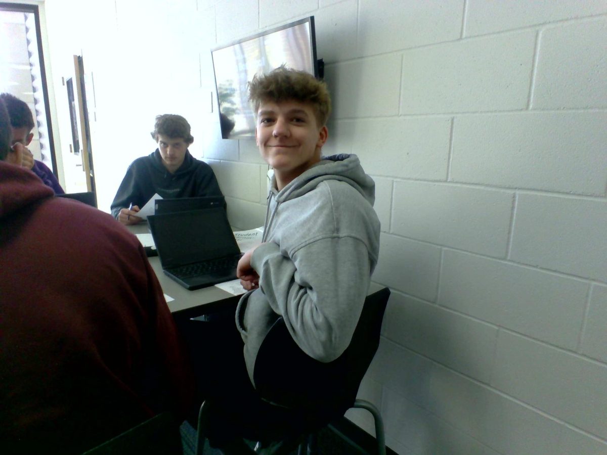 Taven Wurtsberger works with classmates on homework in hallway.