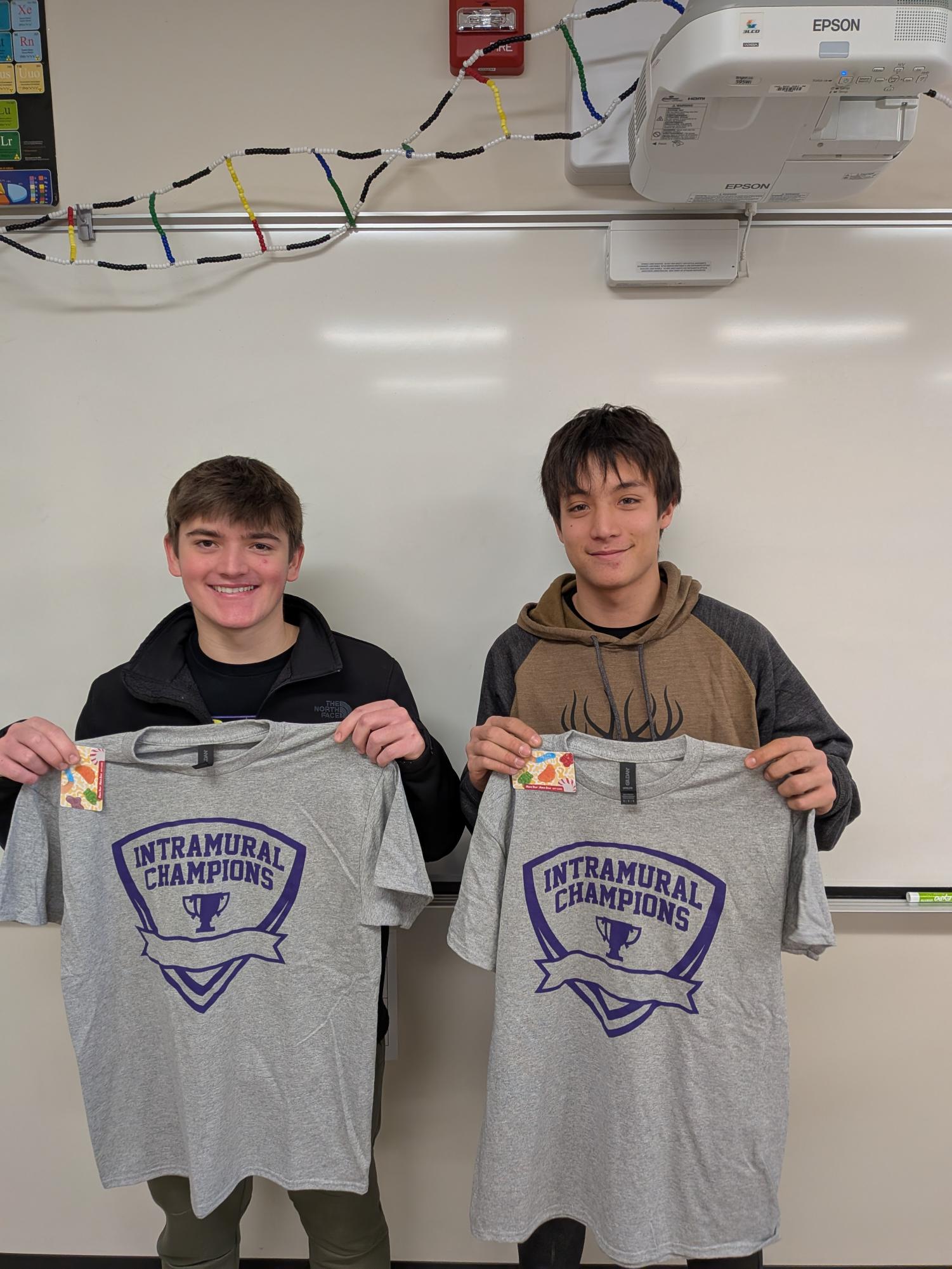 Seniors Collin Forster and Brayden Wendinger showing off their bean bags championship shirts and kiwk trip gift cards.