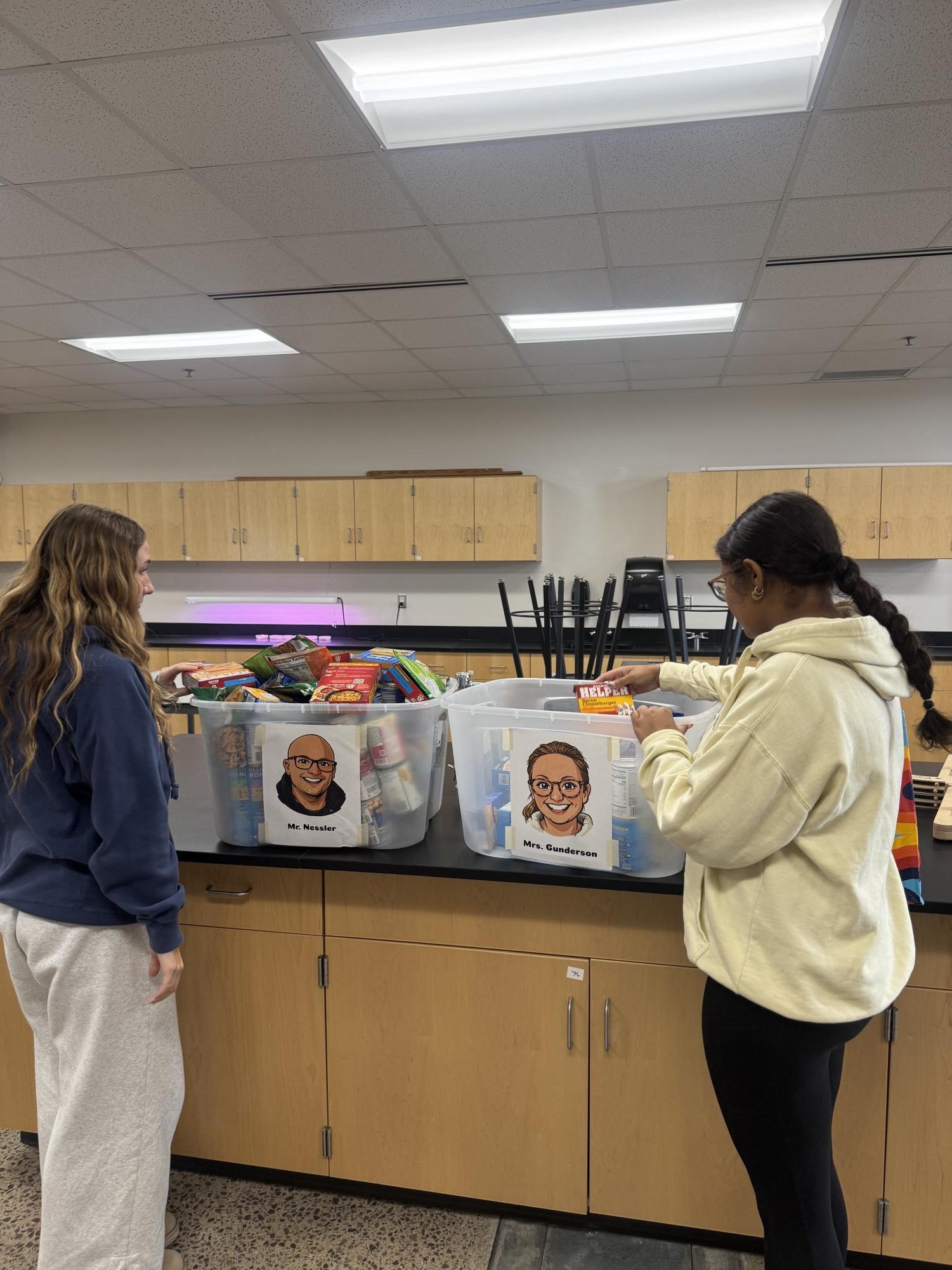 Students look at how many cans were donated to Mr. Nessler's and Mrs. Gunderson's totes