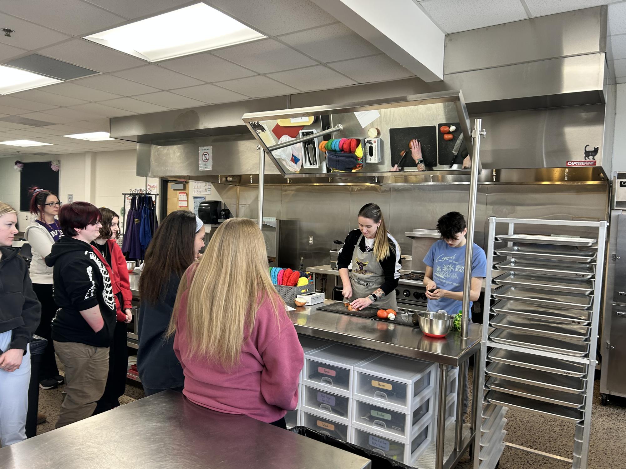 Miss.Schneider demonstrating safe cutting skills with Anthony assisting her