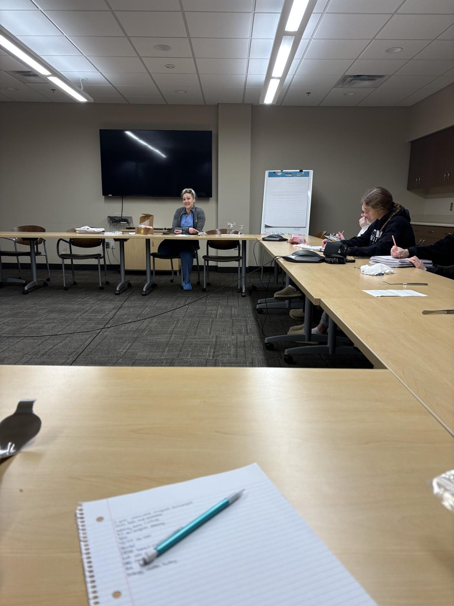 Students take notes while listening to the guest speaker talk about surgeries. 