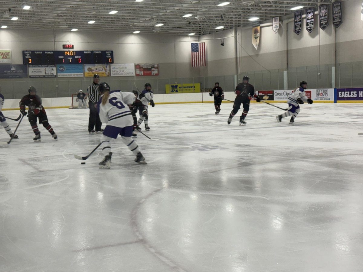 Jersey Haugen, a Junior, passes to her teammate after getting the puck 