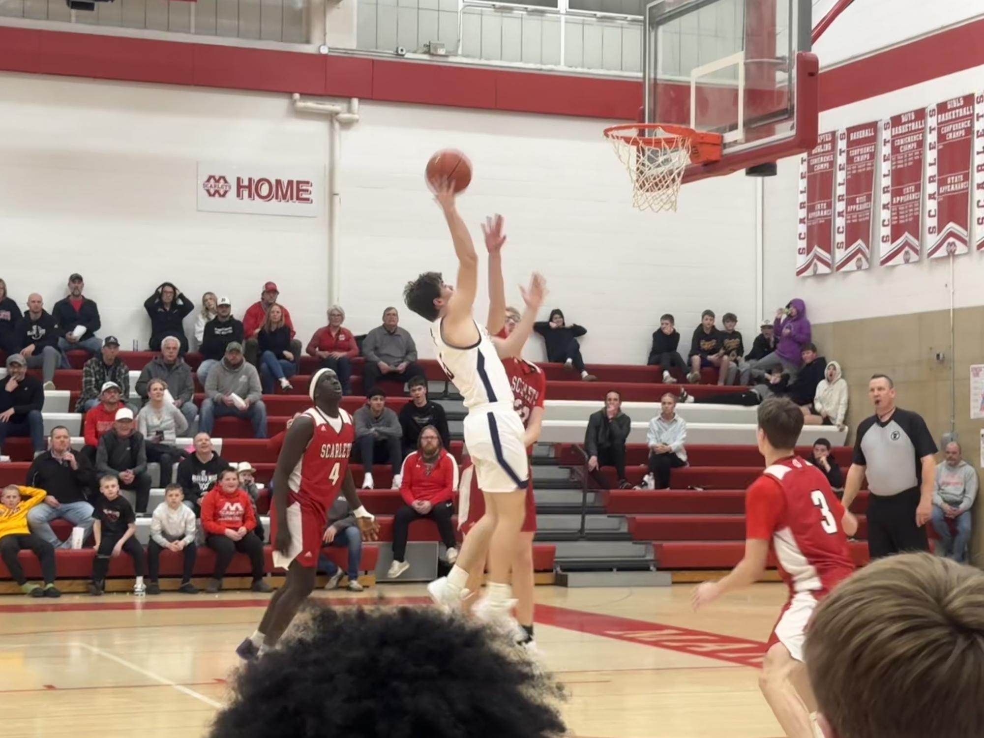 Senior Zach Hubbard goes in for a layup against Mankato defenders 