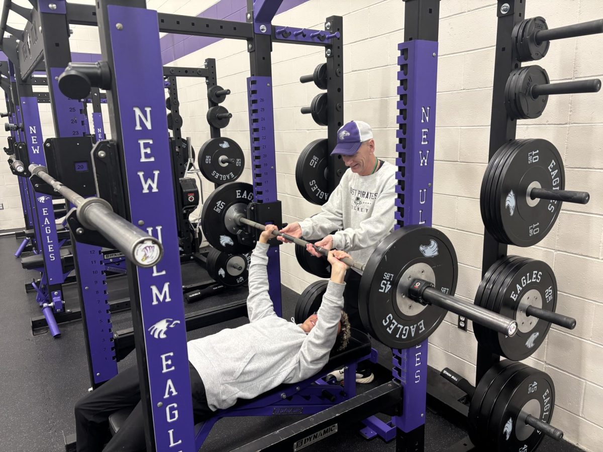 Coach Lundgren assists Jamison Portner on a workout during the off-season lifting program after school.