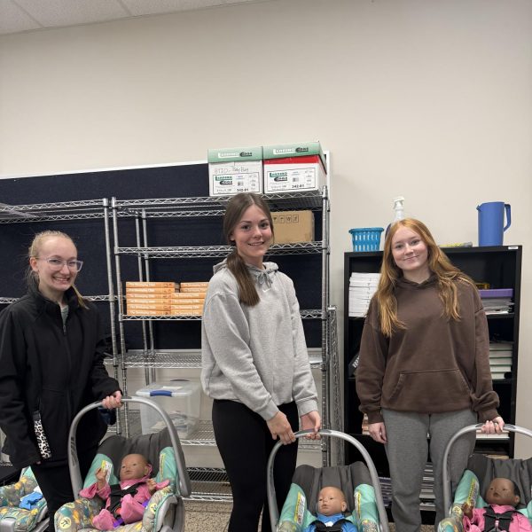 Standing with their RealCare baby, Makaela T, Jacelyn J, and Camryn P.