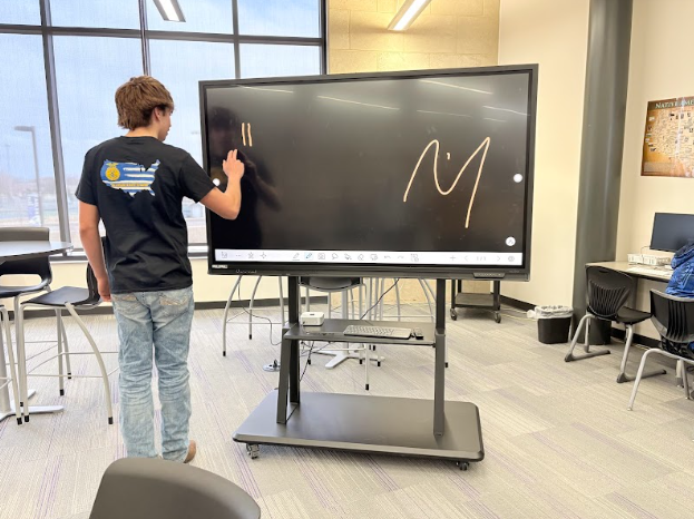 Student testing out drawing on a potential new smart board.