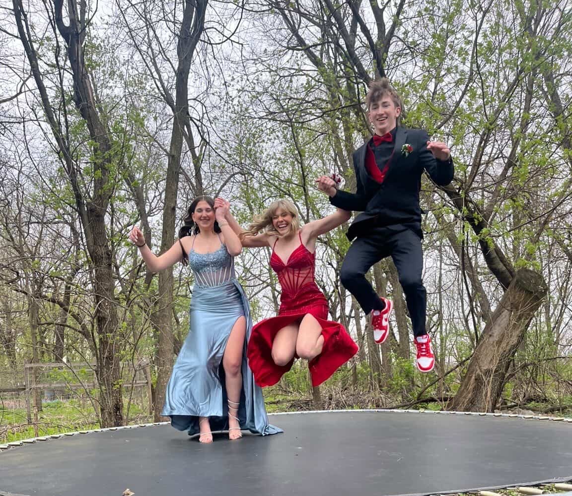 Nicole Zeni, Ellie Anderson, and Kaden Prouse have fun on the trampoline before grand march