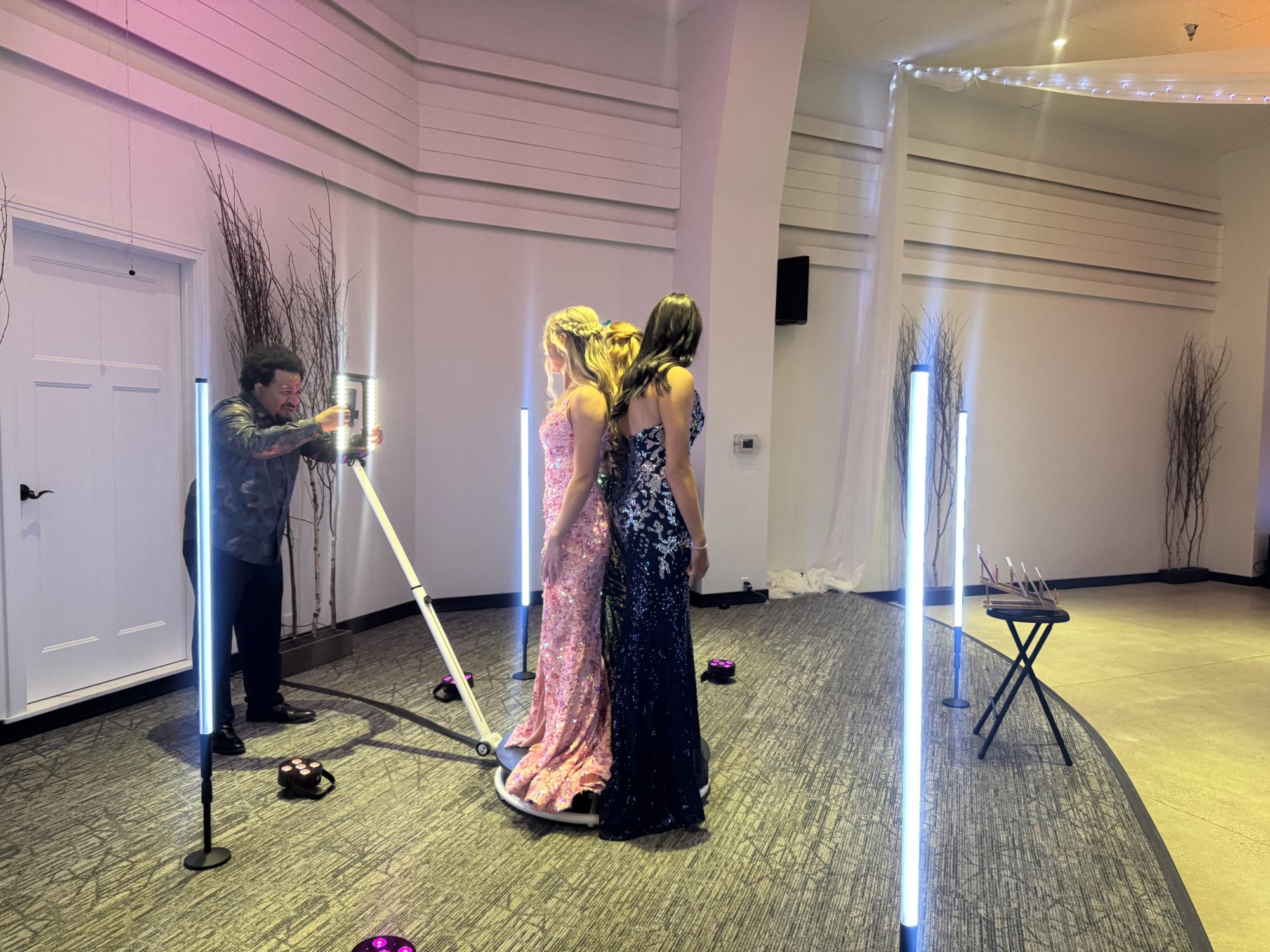 Megan Brudelie, Gracie Baker, and Eliana Cariveau enjoy the 360 photo booth at the prom dance. 