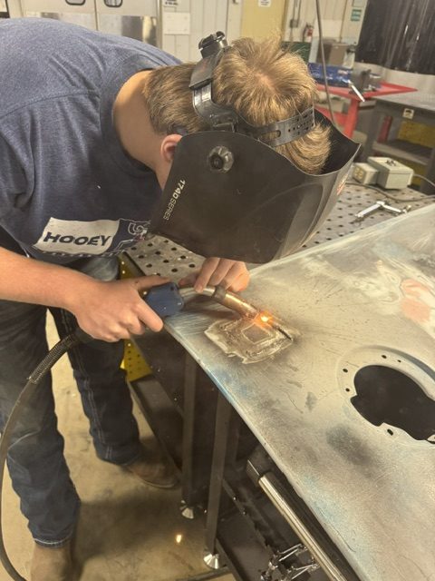 Logan Platz patching in metal on a pickup fender he is replacing.