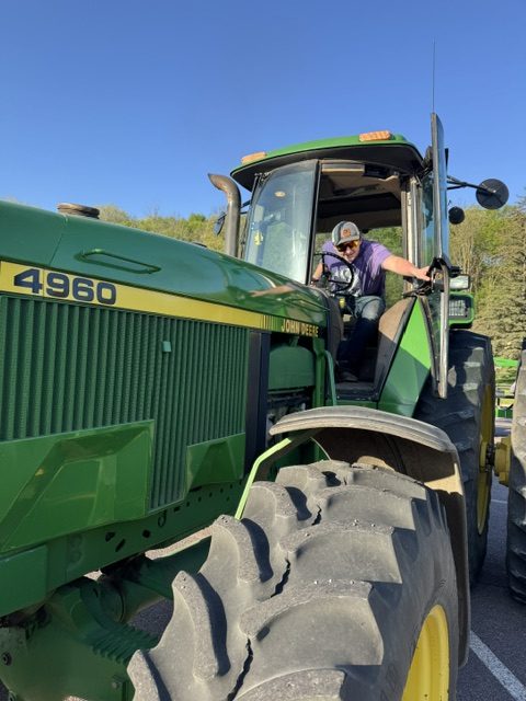 Logan Platz slamming the door on Senior Spencer Drill's Clean John Deere 4960.