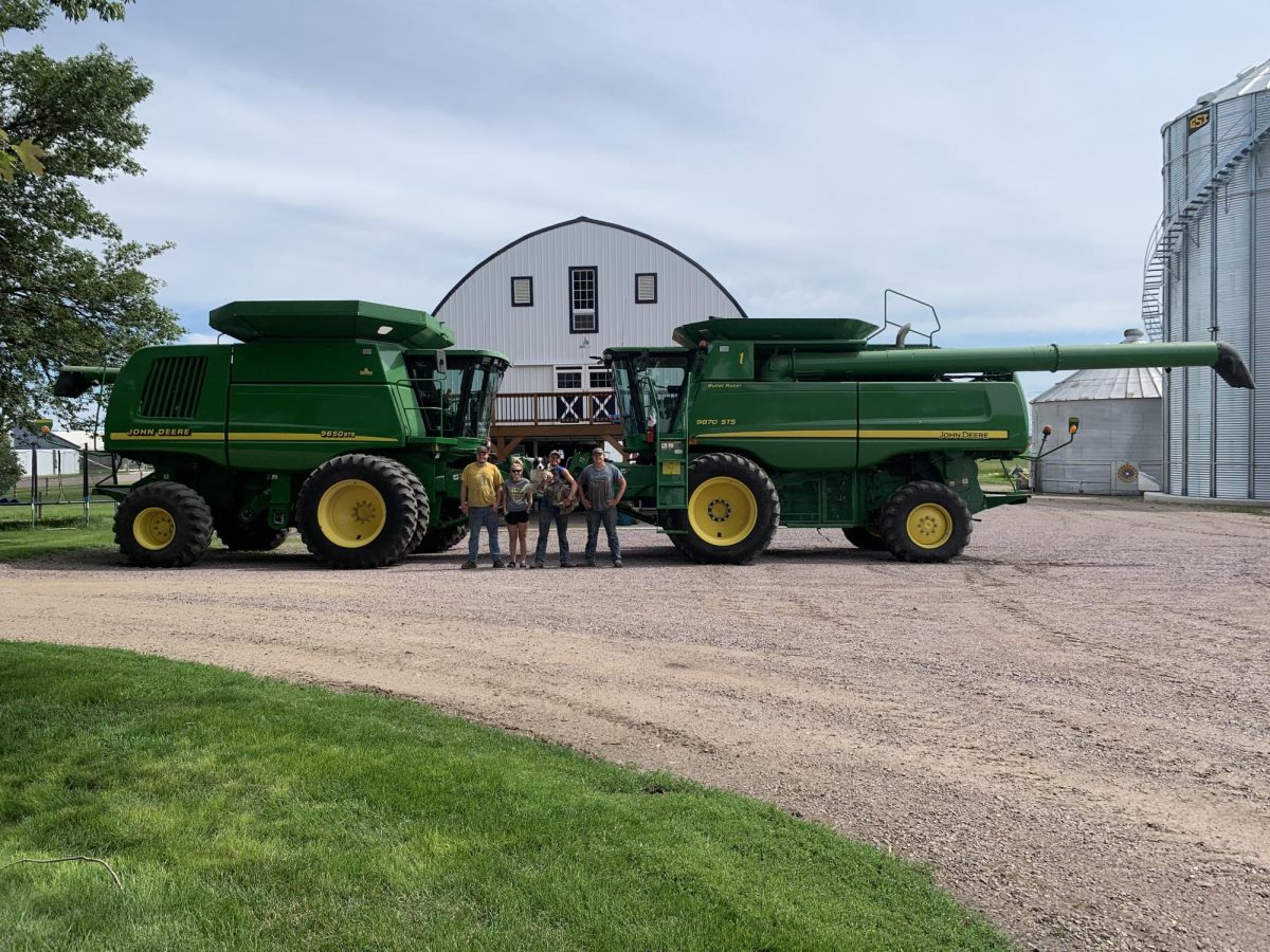 From L to R Jarrett, Cassidy, Kolby, and Logan Platz  in front of there farms Combines. 
