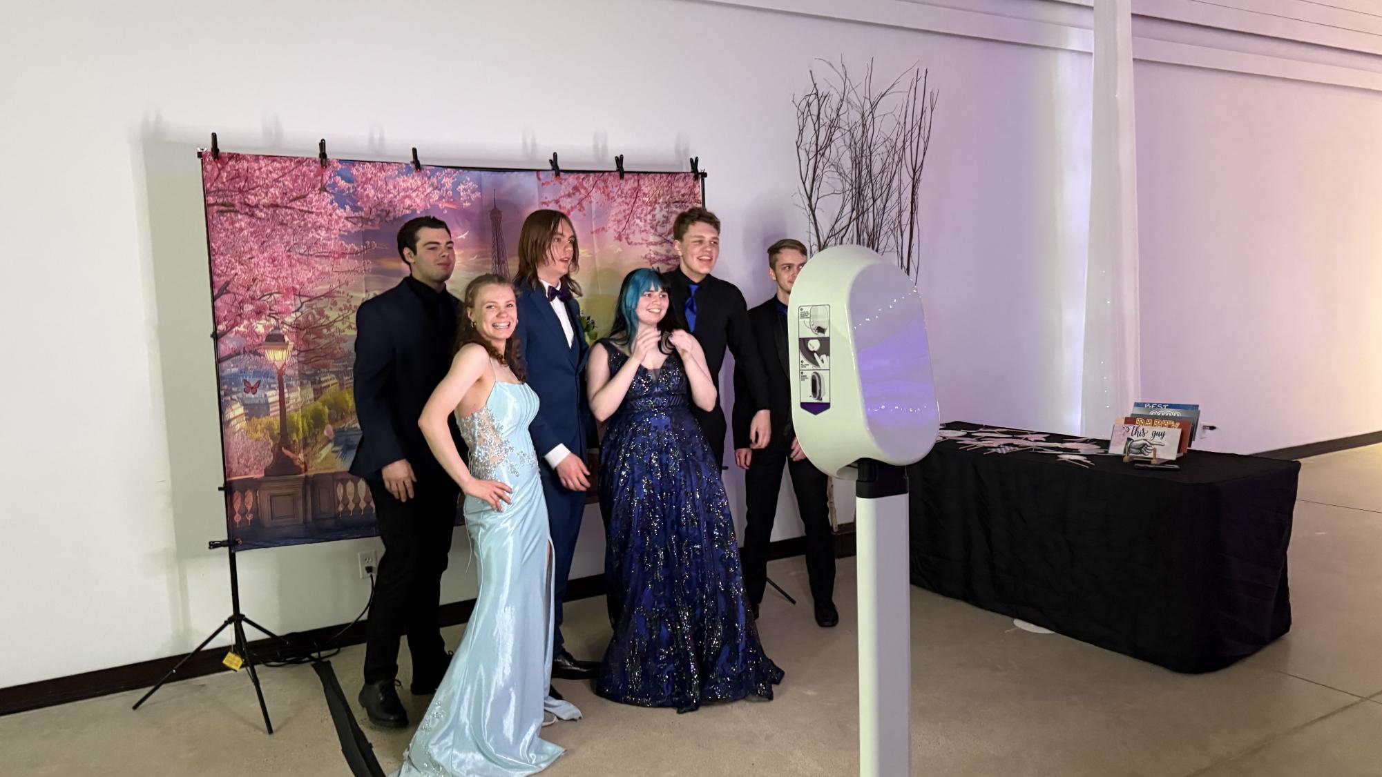 Students taking advantage of the photo booth with Paris backdrop during the Prom dance