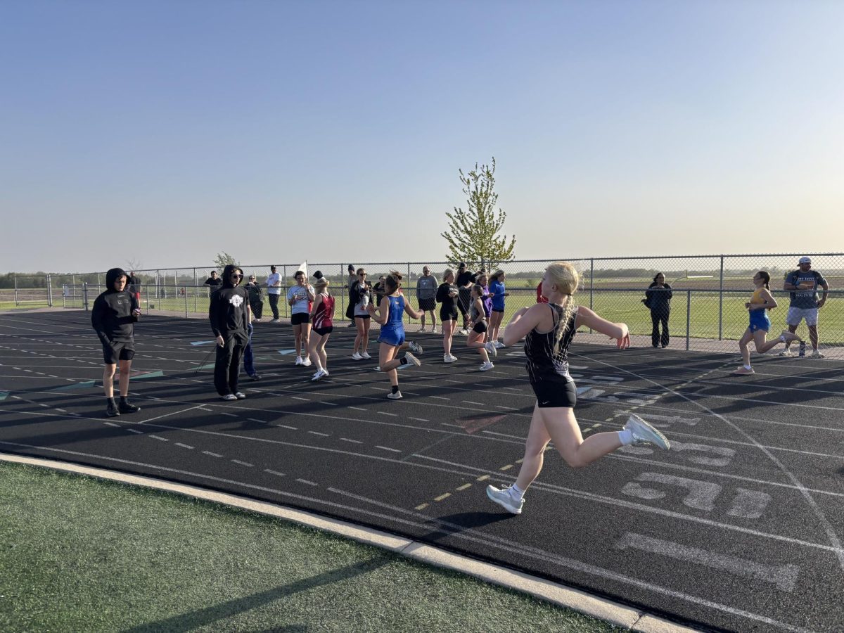 Many Athletes timing the middle school girls 100 meter dash.
