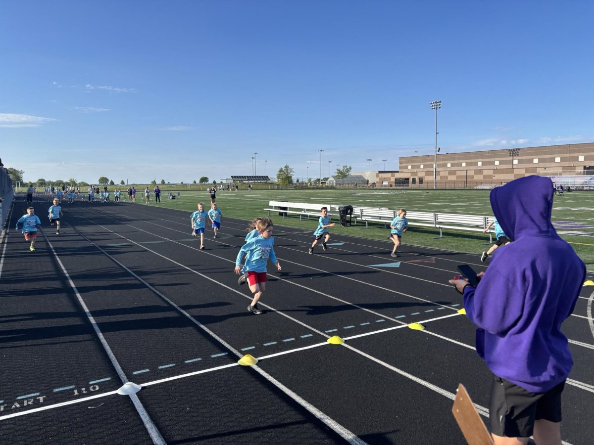 Liam Horner uses a stopwatch to time the little runners