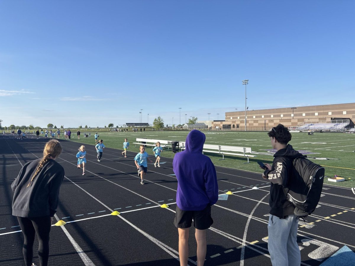Isabelle Longtin, Liam Horner, and Daiven Hesse cheer and collect times for the runners